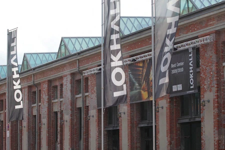 Vor der Lokhalle Göttingen wehen 3 große schwarze Banner mit der Aufschrift Lokhalle.