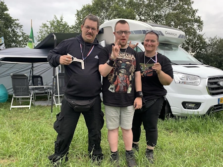 Sven, Stan und Moni stehen als Gruppe auf dem Campground des Wacken Open Air und feiern gemeinsam den gelungenen Tag