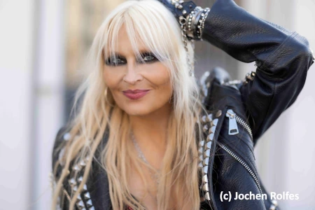 Doro Pesch, die blonde Queen des Metal. Standesgemäß mit Lederjacke, ein Arm lässig hinter den Kopf gelegt