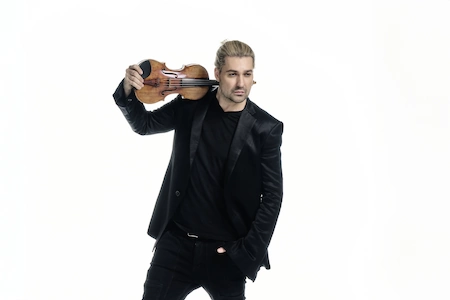 David Garrett der Stargeiger hat lässig seine Geige hinter dem Nacken. Er selbst ist ganz in schwarz gekleidet.